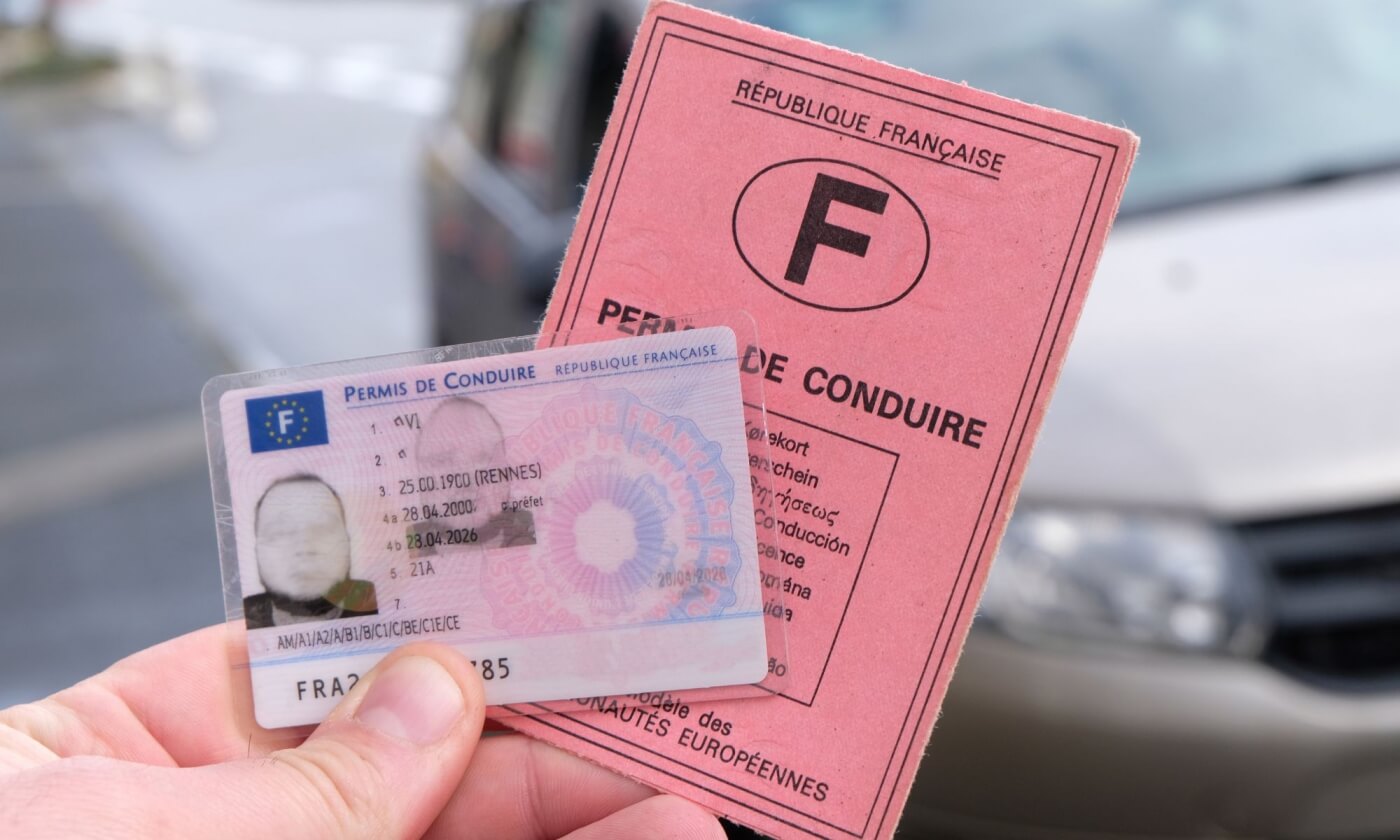 Permis de conduire français, nouvelle carte et ancien modèle rose, tenus en main